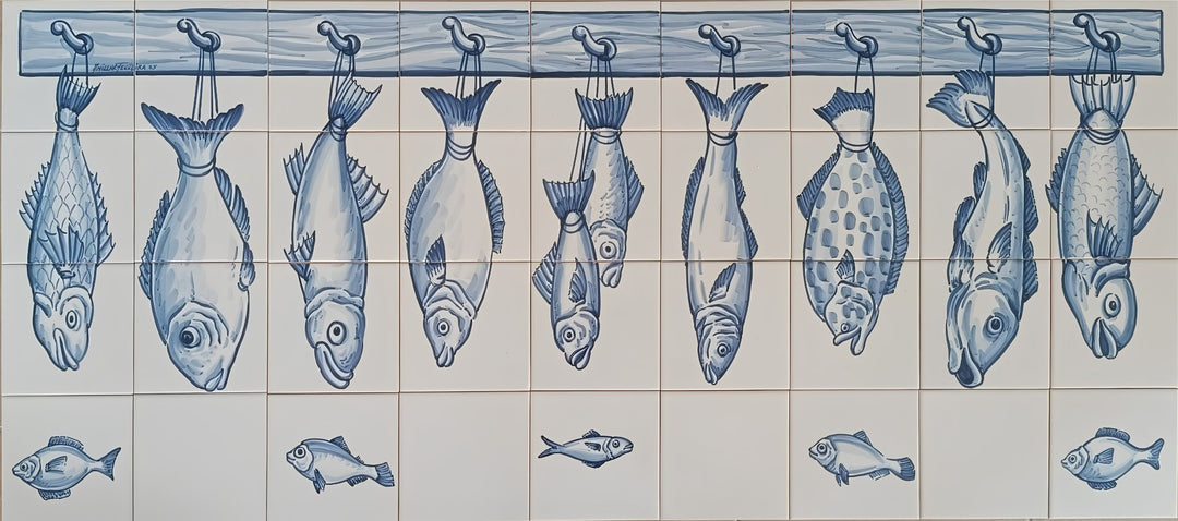 Blue and white Portuguese kitchen tile mural for kitchen splashback featuring illustrated fish hanging from hooks on a wooden bar, with smaller fish motifs along the bottom.