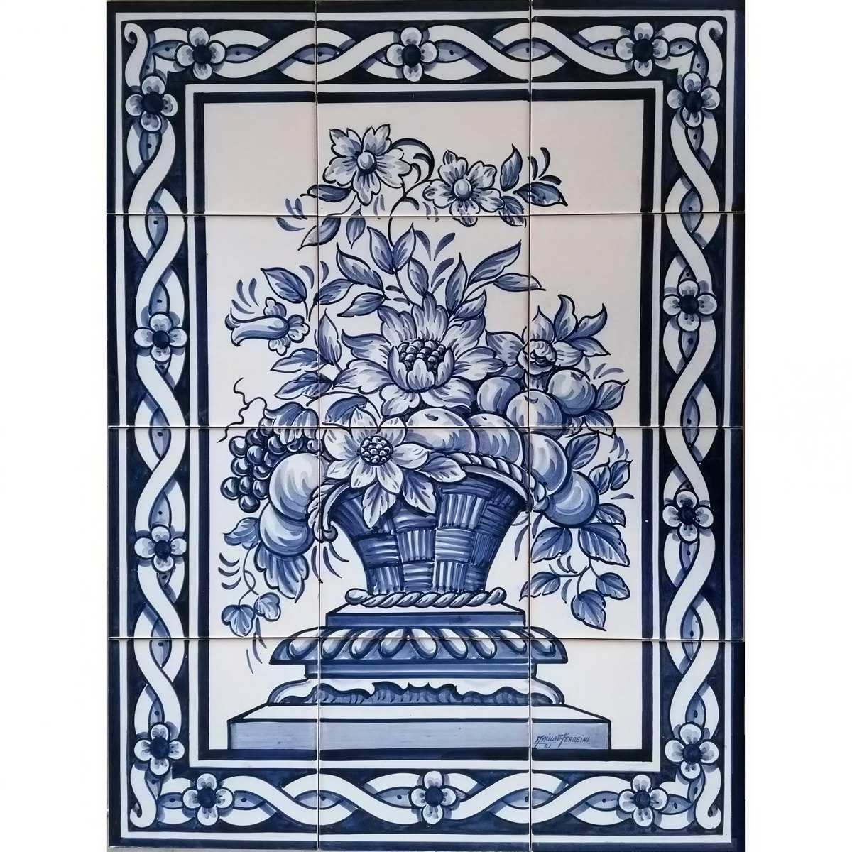 A tile mural featuring a blue and white floral basket motif, hand painted in Portuguese ceramic tiles with a decorative border.