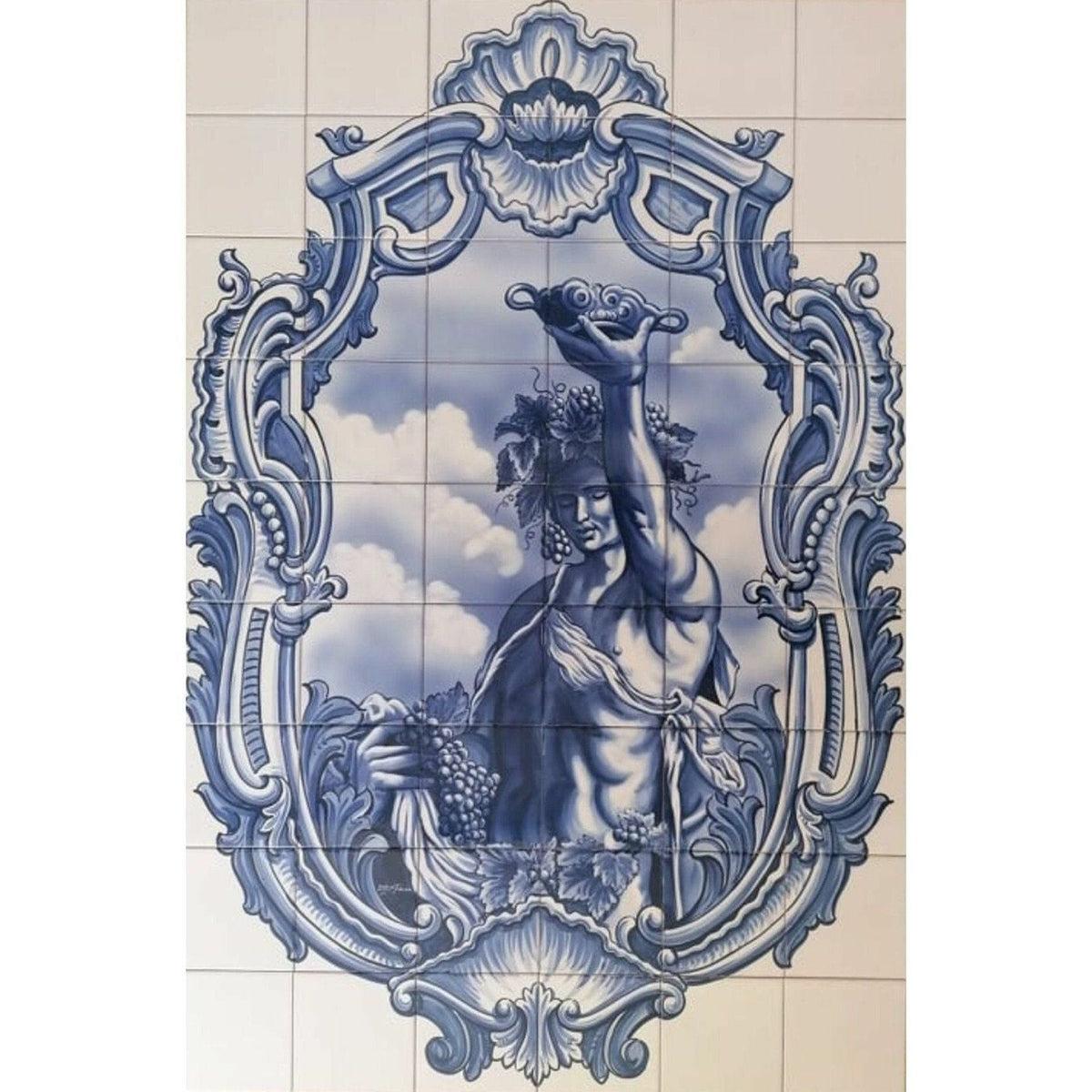 Blue and white Portuguese azulejo tile mural depicting Bacchus holding grapes and a raised goblet, framed by ornate scrollwork and shell motifs. 