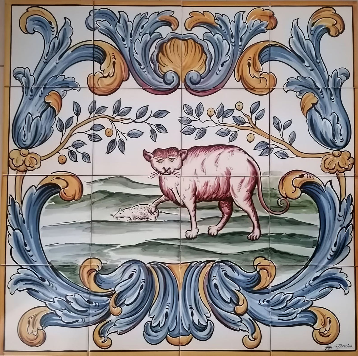 Portuguese tile mural depicting a cat with one paw on a mouse in a green landscape, framed by ornate blue and gold scrollwork.